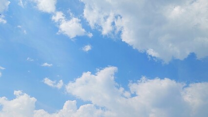 Wall Mural - Blue sky with puffy white cumulus clouds. White cumulus clouds floating in a clear blue sky. Soft white clouds float in the clear blue sky. Natural sky background.