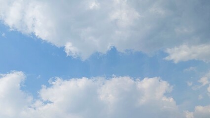 Wall Mural - Blue sky with puffy white cumulus clouds. White cumulus clouds floating in a clear blue sky. Soft white clouds float in the clear blue sky. Natural sky background.