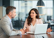 © InfinityVisuals - Negotiation in the Office: Two professionals engage in a focused business discussion, fostering collaboration within a contemporary office environment.