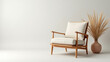 © Olha - Wooden armchair with white cushion and dried grass in cozy minimalist room