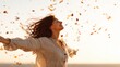 © mila103 - A woman stands with her arms wide open, embracing the golden hues of a sunset. Leaves gently fall around her, capturing the essence of joy and freedom in the autumn air.