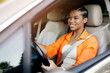 © Anastasiya - African American woman smiling while driving car with focus and confidence. Concept of safe driving, joy, and everyday lifestyle moments on the road
