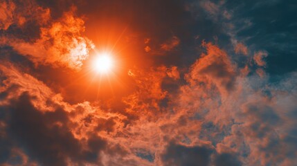 Wall Mural - A vibrant orange sun hovers in a cloudy sky, casting dramatic light over the horizon during late afternoon. The clouds are illuminated with shades of orange and gray.