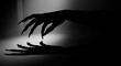 © CandyLove - A grayscale image displaying a dark silhouette of a hand with long sharp fingers and its shadow