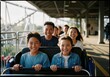 © Chattraporn - Happy Asian family enjoying a roller coaster ride at amusement park