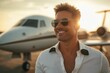 © Максим Фокин - A man in sunglasses stands beside a private jet, smiling as the sun sets in the background