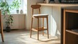 © Xeyal - Modern wooden bar stool with upholstered seat bathed in natural light near a kitchen counter