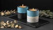 © prodip - Two decorative candles on a black slate board with eucalyptus branches