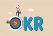 © Yeasin - OKR, objective and key result framework to measure success and improvement, goal setting or define measurable target for business concept, businessman holding winning flag on target with the work OKR.