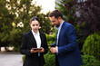 Coffee to go. Man with paper cup of drink and his business partner during meeting outdoors