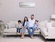 © New Africa - Happy family on sofa in living room. Air conditioner keeping comfortable temperature in room