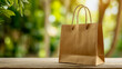 © Daria - Eco-friendly brown kraft paper shopping bag with twisted handles set on wooden surface in a blurred green natural outdoor environment background