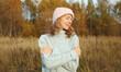 © rohappy - Happy smiling woman hugs herself in autumn park enjoying warm weather on sunny day outdoors