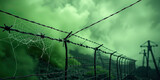 Barbed wire fence with spider web against eerie green fog and abandoned power lines, spooky halloween background symbolizing fear, dystopian atmosphere and mysterious horror