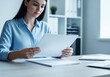 © gunawan - Businesswoman Reading Documents Focused.