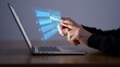 © NurJahan - Person interacting with futuristic holographic data display on laptop