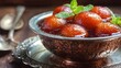 © Nattapol - Indian gulab jamun in syrup in traditional bowl, side composition with right copy space