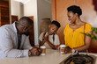 © wavebreak3 - Family enjoying morning coffee together in kitchen, sharing joyful conversation