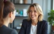 © hao - Happy mature professional business woman executive hr manager having job interview or business discussion with female applicant or colleague sitting at workplace in corporate office meeting.