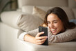 © Antonioguillem - Happy woman laughing watching online content on mobile phone