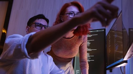 Developers collaborating on coding project, pointing at computer screen with code. Concept of teamwork, learning to code, software development, and business technology solutions in modern workplace.