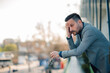 © Zamrznuti tonovi - Stressed businessman leaning on balcony holding glasses is feeling worried