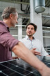 © Westend61 - Young businessman planning business strategy with manager holding solar panel in factory
