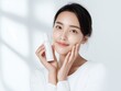 © Jumpei - スキンケア化粧品を持つ笑顔の若い日本人女性ポートレート