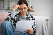 © Ievgen Skrypko - Girl In Glasses Reads A Payment Information Letter About A Credit Or Rent Invoice