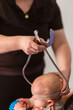 © Austockphoto - Physio performing Cranial Shape Measurement assessment Using a Caliper tool and Elastic Band