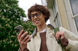 © Bliss - Exciting outdoor stroll for a young student enjoying a sunny day while checking his phone