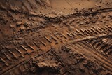 Close-up of deep tire tracks in wet brown mud, textured and rugged surface, perfect for off-road concepts, construction themes, adventure backgrounds, and industrial marketing visuals.