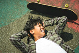nice Boy with skateboards outside on skate playground having head injury