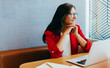 © (JLco) Julia Amaral - Businesswoman in red blazer working at her laptop in an office setting