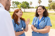 © StockMe - Cheerful doctors and nurses enjoying a friendly conversation outdoors, fostering teamwork and collaboration in a healthcare setting