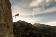 © VICTOR - A man is jumping off a cliff with a rope attached to him