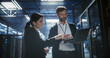 © Aleksei Gorodenkov/Stocksy - Two server specialists talk and work in data center.