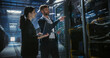 © Aleksei Gorodenkov/Stocksy - Two technicians talk, use laptop and work in data center.