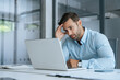 © Stock 4 You - Confused young businessman looking disappointed at laptop pc computer screen having stress. European business man holding hand near temples, feeling stressed and tired sitting at workplace in office.