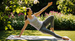 © Ivul - Young Woman Performing Yoga on a Mat Outdoors in a Lush Green Garden with Flowers in the Background