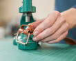 © Михаил Решетников - A woman attaches accessories to a leather belt. Leatherworker's workshop.