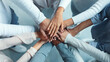 © Prostock-studio - Top view of multiracial business team demonstrating cooperation with putting their hands together on top of each other