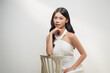 © Marc Tran/Stocksy - A stunning asian woman poses gracefully in a white dress