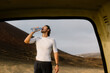 © Adrian Rodd/Stocksy - Trail runner drinking water from plastic bottle after intense training
