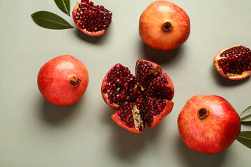 Wall Mural - fresh pomegranates and leaves on green background