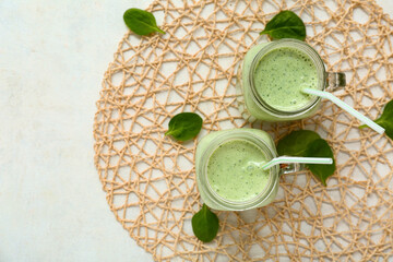 Wall Mural - Mason jars of fresh spinach smoothie on white background