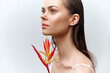 © VICHIZH - Elegant woman portrait with exotic flower, showcasing natural beauty and serene emotion in soft colors, perfect for beauty and wellness themes.