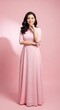 © Rosie Lee - Elegant Young Woman in a Pink Dress Posing Gracefully Against a Soft Pink Background