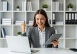 © MstMorjina - Young businesswoman celebrating success with laptop and tablet in office celebration achievement