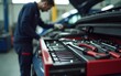 © Daniel - Selective focus on mechanic's toolbox with tools in drawer with auto-mechanic fixing car in blurry background at workshop. High quality